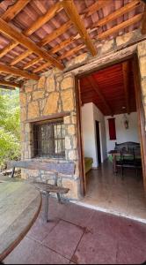 an outdoor patio with a table and a stone wall at Cabaña Camping Cabalango in Cavalango