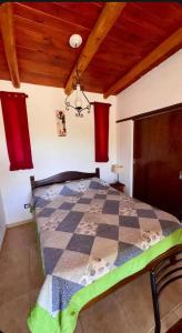 a bedroom with a checkered bed in a room at Cabaña Camping Cabalango in Cavalango