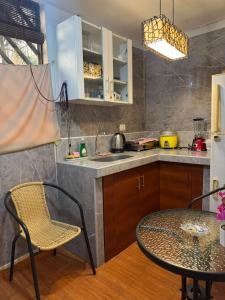a kitchen with a table and a table and chairs at Hospedaje el Trujillanito in Víctor Larco Herrera