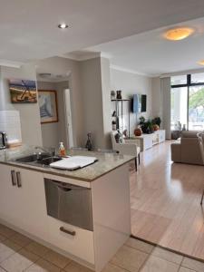 a kitchen with a sink and a living room at Seaside Escape Rockingham in Rockingham