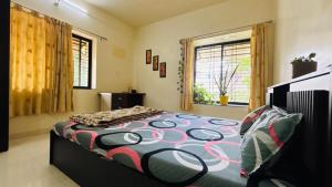a bedroom with a bed with a colorful comforter at Nasik Homestay in Nashik