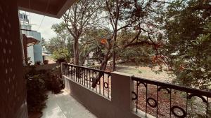a balcony of a house with a fence and trees at Nasik Homestay in Nashik
