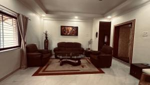a living room with couches and a coffee table at Nasik Homestay in Nashik