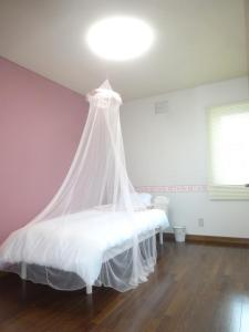 a bedroom with a bed with a mosquito net at 愛灯-ｉｔｏ- in Kami-furano