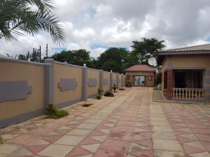 a walkway next to a fence and a building at Rugems Executive Lodge in Lusaka