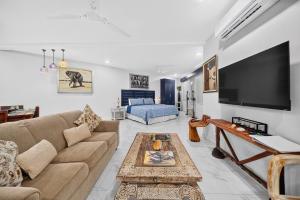 a living room with a couch and a flat screen tv at Buena Vista Plus in Quepos