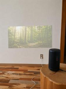 a painting of a forest on a wall in a room at IWAKI Stay KAKUREGI in Hirosaki