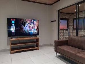 a living room with a couch and a flat screen tv at Klein Plasie - St Helena Bay in Stompneusbaai +7 photos