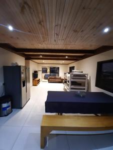 a living room with a blue bed and a kitchen at Klein Plasie - St Helena Bay in Stompneusbaai