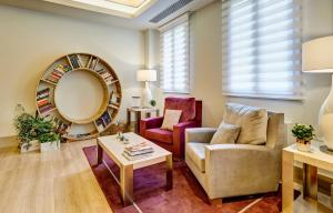a living room with a couch and a mirror at Sercotel Alcalá 611 in Madrid