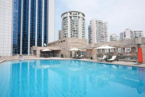a large swimming pool in a city with tall buildings at Wyndham Garden Haikou Meilan in Haikou