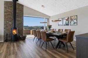 a dining room with a fireplace and a table and chairs at 839-Harboore-Strandvaenget-6 in Harboør