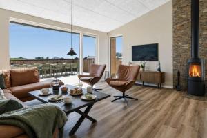 a living room with a couch and a fireplace at 839-Harboore-Strandvaenget-6 in Harboør