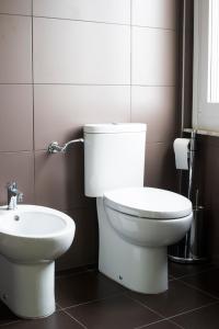 a bathroom with a white toilet and a sink at Albergo Colonna in Bertinoro