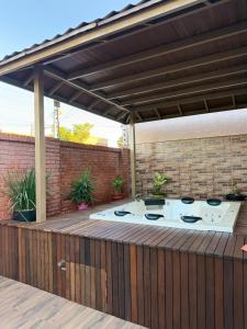 a patio with a barbecue grill on a wooden deck at Pousada Lumiera House in Foz do Iguaçu