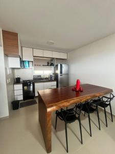 a kitchen with a wooden table and some chairs at Canoa Breeze - Beach Front in Canoa Quebrada