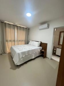 a bedroom with a white bed and a window at Canoa Breeze - Beach Front in Canoa Quebrada +43 photos
