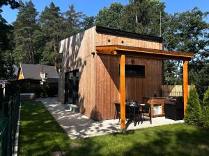 a small wooden building with a table in a yard at Glamping Hynkov in Příkazy