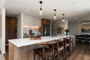 a kitchen with a large island with bar stools at Alpine Retreat in Methven