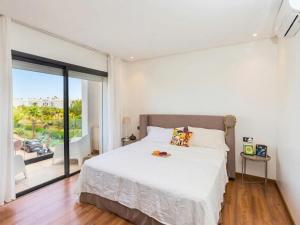 a bedroom with a white bed and a large window at Villa Séréna Pool and Comfy in Tamaris