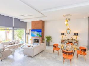 a living room with a couch and a table and chairs at Villa Séréna Pool and Comfy in Tamaris