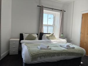 a bedroom with a bed with two towels on it at Edenderry Central Rooms in Edenderry