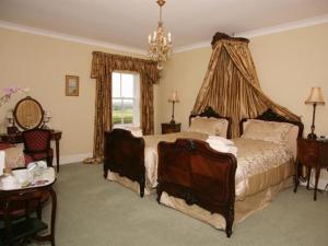 a bedroom with a bed and a chandelier at West Longridge Manor B&B in Berwick-Upon-Tweed