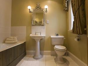 a bathroom with a toilet and a sink and a mirror at West Longridge Manor B&B in Berwick-Upon-Tweed +4 photos