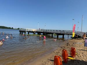a group of people swimming in the water near a pier at Chill and Grill Apartment in Wola Smolana +8 photos