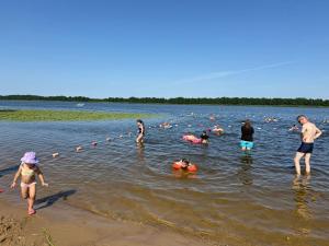 a group of people in the water at a lake at Chill and Grill Apartment in Wola Smolana