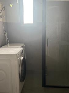 a washing machine in a bathroom with a window at Chill and Grill Apartment in Wola Smolana