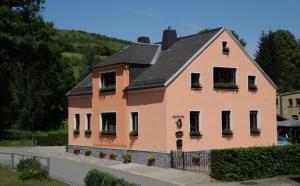 a large pink house with a black roof at Pension & Ferienwohnung Eitler in Aue-Bad Schlema