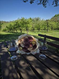a bouquet of flowers on a table with two wine glasses at Bajta 163 in Topusko