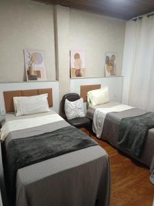 a room with two beds in a room at Vista do pico Itacolomi in Ouro Preto +3 photos