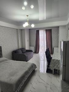 a bedroom with a bed and a couch and a table at bakuriani mix 504 in Bakuriani