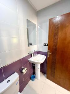 a bathroom with a sink and a toilet and a mirror at Visit Chamal - Palmera 3 in Oued Laou