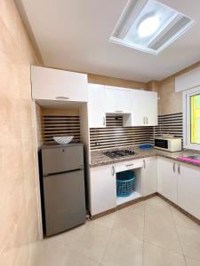 a kitchen with white cabinets and a refrigerator at Visit Chamal - Palmera 3 in Oued Laou