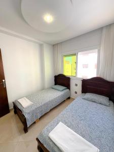 a bedroom with two beds and a window at Visit Chamal - Palmera 3 in Oued Laou