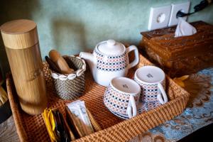 a basket with cups and utensils on a table at Puri Mayapada Nusa Dua Bali in Nusa Dua