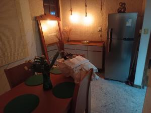 a kitchen with a refrigerator and a table with a mirror at Vista do pico Itacolomi in Ouro Preto