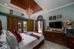 a bedroom with a bed and a flat screen tv at Puri Mayapada Nusa Dua Bali in Nusa Dua