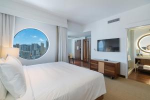 a bedroom with a large white bed and a window at Hyatt Centric Waikiki Beach in Honolulu