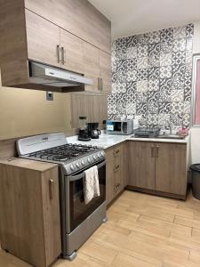 a kitchen with wooden cabinets and a stove top oven at Casa Zaabi in Oaxaca City +20 photos