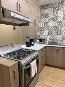 a kitchen with a stainless steel stove top oven at Casa Zaabi in Oaxaca City