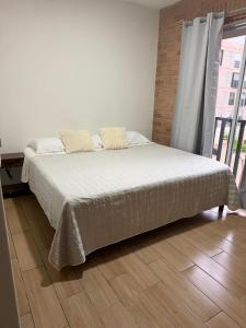 a bed in a bedroom with a large window at Casa Zaabi in Oaxaca City