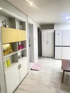 a kitchen with white cabinets and a pink rug at 외국인여성전용게스트하우스 in Pup'yŏng-yŏk