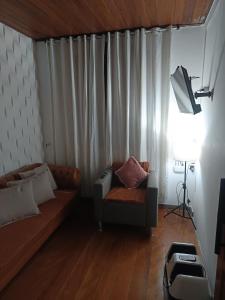 a living room with a couch and a chair at Vista do pico Itacolomi in Ouro Preto