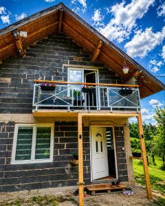 a house with a balcony on the front of it at Green Escape in Zavidovići