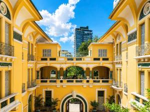 a yellow building with an archway in a city at G8 Diamond Hotel Saigon in Ho Chi Minh City