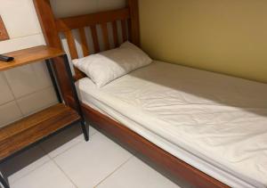 a small bed with a pillow on it in a room at Figueiredo Hosp 2 in Presidente Figueiredo